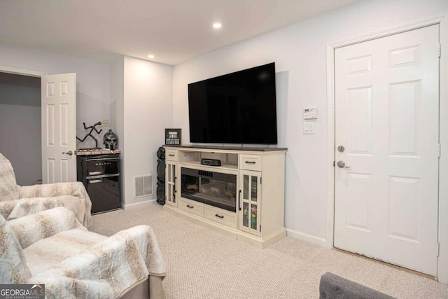 carpeted living area featuring baseboards, visible vents, and recessed lighting