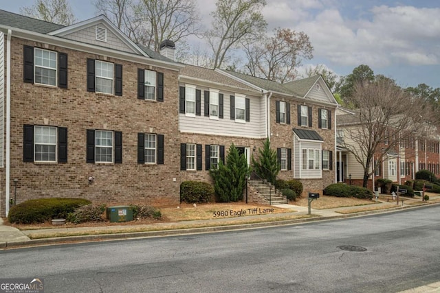 multi unit property featuring cooling unit, brick siding, and a chimney
