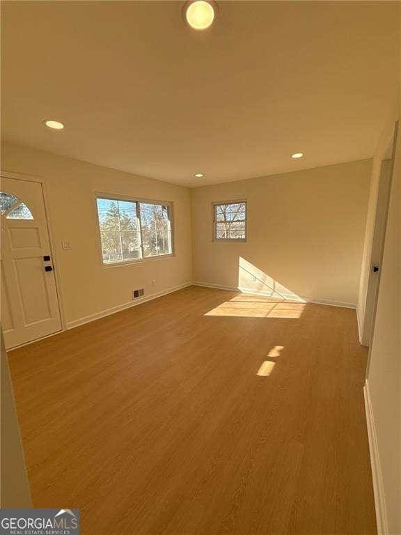 empty room with visible vents, baseboards, recessed lighting, and wood finished floors