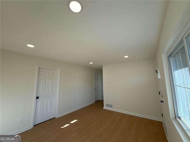 empty room featuring baseboards, wood finished floors, and recessed lighting