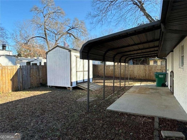 view of car parking with a fenced backyard, a carport, and a storage shed