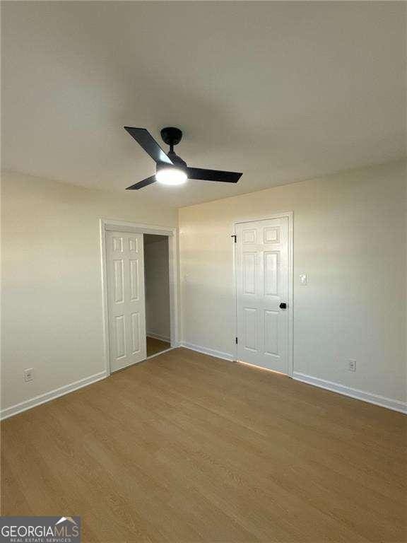unfurnished bedroom with baseboards, ceiling fan, and wood finished floors