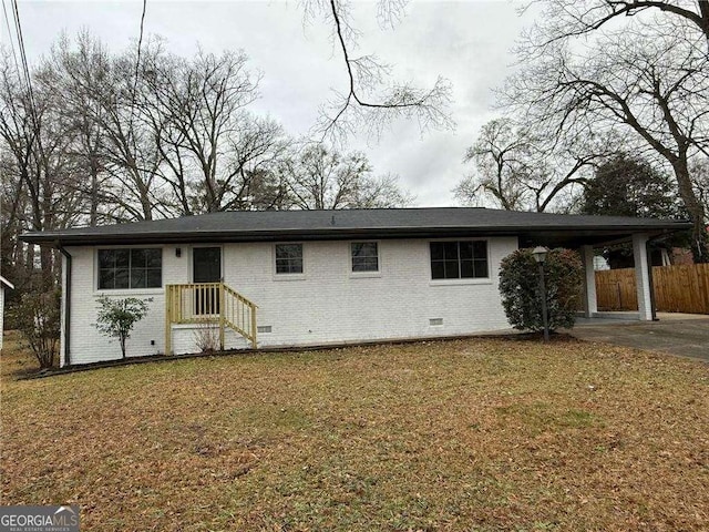 ranch-style house with a front lawn, an attached carport, fence, and brick siding