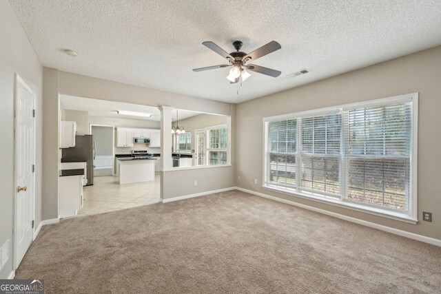 3936 Toccoa Falls Dr, Duluth, GA 30097 - unfurnished living room with a ceiling fan, light carpet, healthy amount of natural light, a textured ceiling, and baseboards
