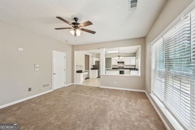 3936 Toccoa Falls Dr, Duluth, GA 30097 - unfurnished living room with ceiling fan, light colored carpet, healthy amount of natural light, baseboards, and a textured ceiling