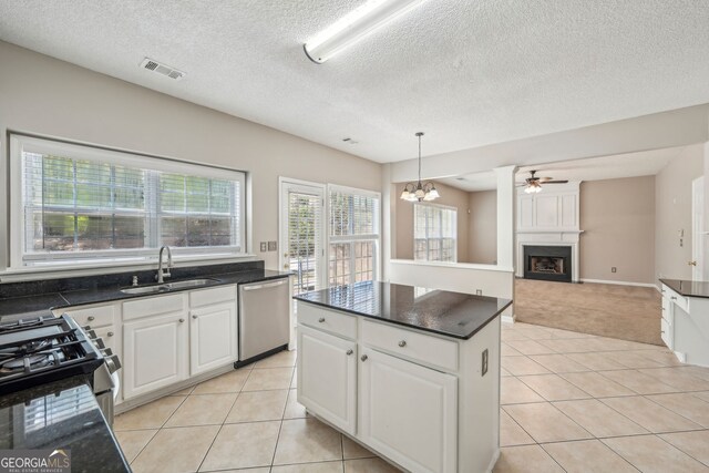 3936 Toccoa Falls Dr, Duluth, GA 30097 - kitchen with appliances with stainless steel finishes, a sink, light tile patterned flooring, a fireplace, and a kitchen island