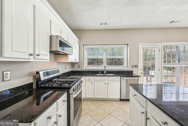 3936 Toccoa Falls Dr, Duluth, GA 30097 - kitchen with stainless steel appliances, a sink, white cabinetry, a textured ceiling, and dark stone countertops
