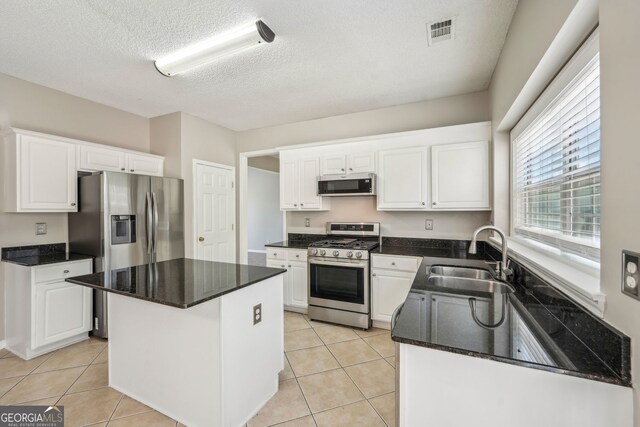 3936 Toccoa Falls Dr, Duluth, GA 30097 - kitchen featuring stainless steel appliances, a sink, white cabinets, light tile patterned floors, and a textured ceiling