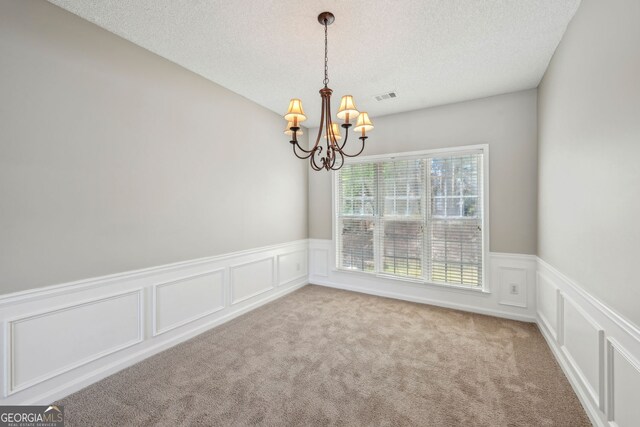 3936 Toccoa Falls Dr, Duluth, GA 30097 - carpeted spare room featuring a chandelier, a textured ceiling, a wainscoted wall, and a decorative wall