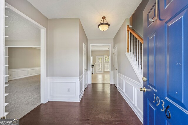 3936 Toccoa Falls Dr, Duluth, GA 30097 - foyer entrance featuring stairs, a wainscoted wall, dark wood-type flooring, and a decorative wall