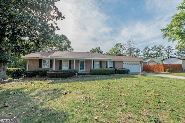 ranch-style house featuring concrete driveway, a front lawn, an attached garage, brick siding, and fence