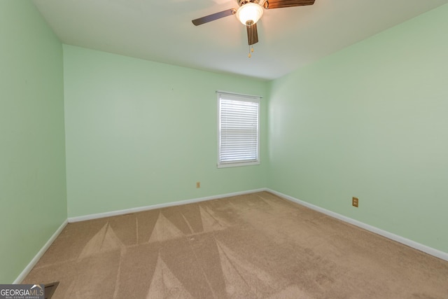 carpeted empty room featuring baseboards and ceiling fan