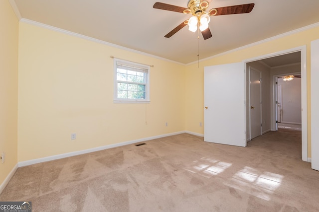 carpeted empty room featuring visible vents, ornamental molding, and ceiling fan