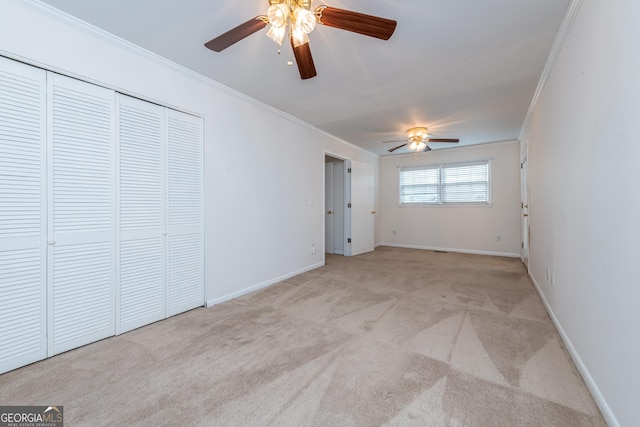 unfurnished bedroom with crown molding, carpet floors, baseboards, and a closet