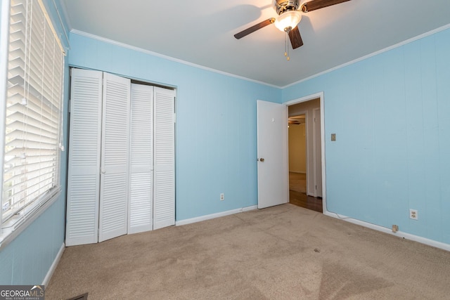unfurnished bedroom with baseboards, carpet, a closet, and ornamental molding