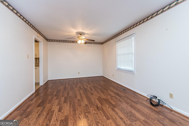 spare room with wood finished floors, baseboards, a ceiling fan, and visible vents