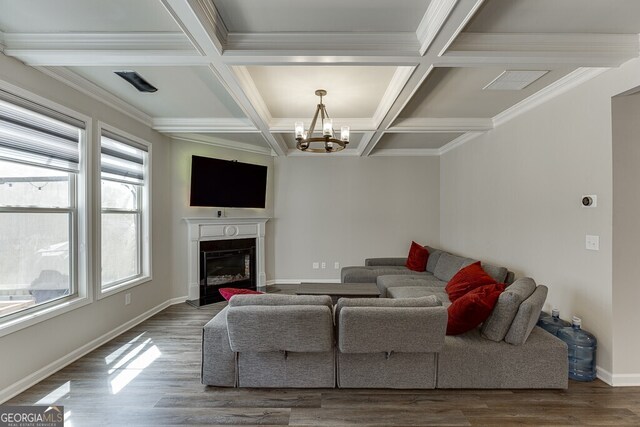 living area featuring a notable chandelier, coffered ceiling, baseboards, and wood finished floors