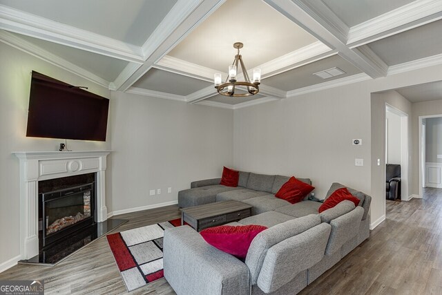 living area with visible vents, coffered ceiling, a notable chandelier, and wood finished floors