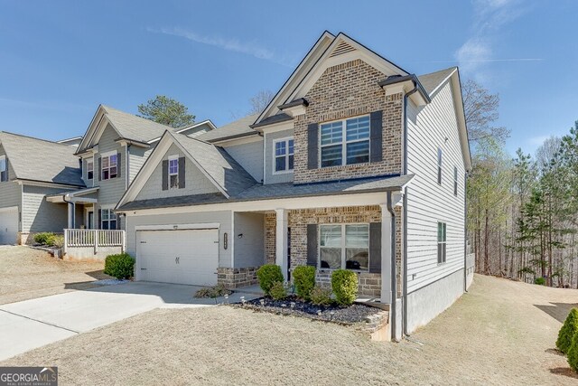craftsman-style home with stone siding, concrete driveway, and a porch