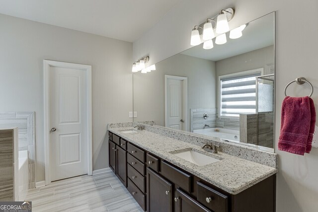 bathroom featuring double vanity, baseboards, a sink, and a garden tub