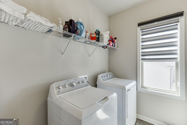 laundry area featuring washing machine and clothes dryer, baseboards, and laundry area
