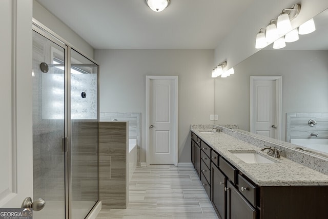 bathroom featuring a bath, double vanity, and a sink