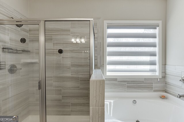 bathroom featuring a bath and a stall shower