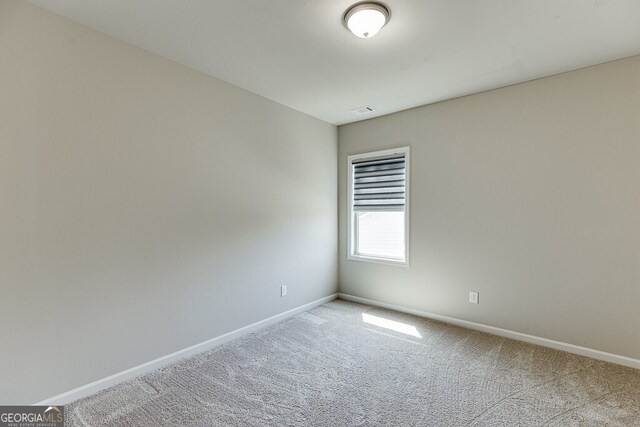 carpeted spare room with baseboards and visible vents
