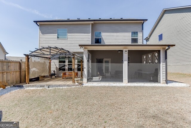back of property featuring a sunroom and fence