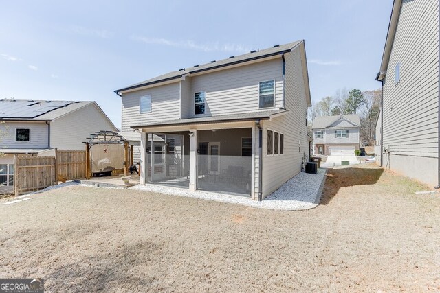 back of property featuring a sunroom, fence, and cooling unit