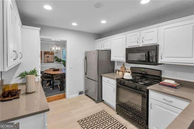 656 Channing Dr NW, Atlanta, GA 30318 - kitchen with black appliances, white cabinetry, recessed lighting, and a chandelier
