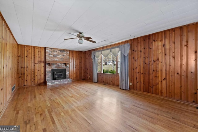 unfurnished living room featuring light wood-type flooring, a ceiling fan, baseboards, and visible vents