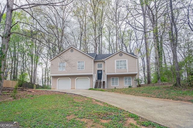 bi-level home featuring driveway, an attached garage, and a chimney