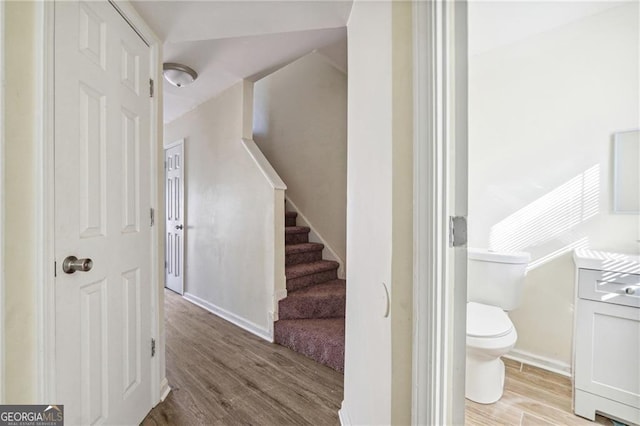 stairway with baseboards and wood finished floors
