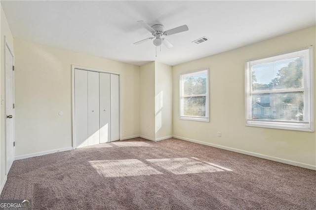 unfurnished bedroom with baseboards, visible vents, a closet, and carpet flooring