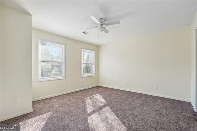 unfurnished room with carpet floors, baseboards, visible vents, and ceiling fan