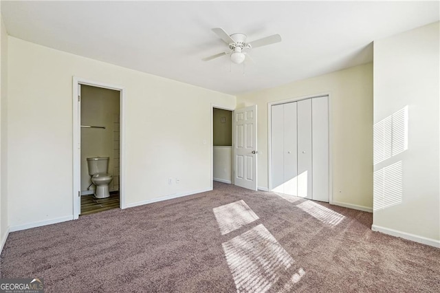 unfurnished bedroom featuring a closet, carpet flooring, a ceiling fan, ensuite bath, and baseboards