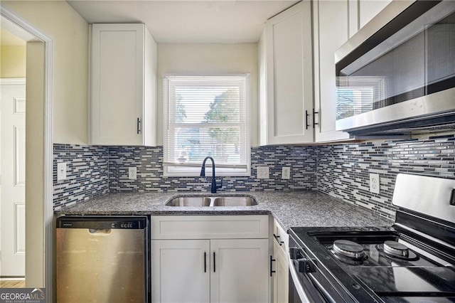 kitchen with white cabinetry, a sink, stainless steel appliances, and backsplash