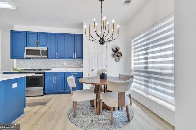 dining space featuring visible vents, a chandelier, and light wood-type flooring