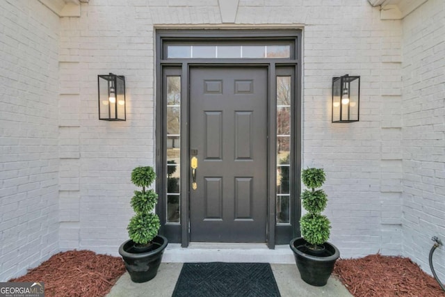 entrance to property featuring brick siding