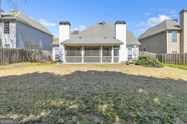 rear view of house with a sunroom, a shingled roof, a fenced backyard, and a yard