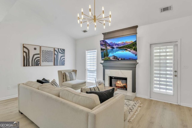 living room featuring wood finished floors, a notable chandelier, and visible vents