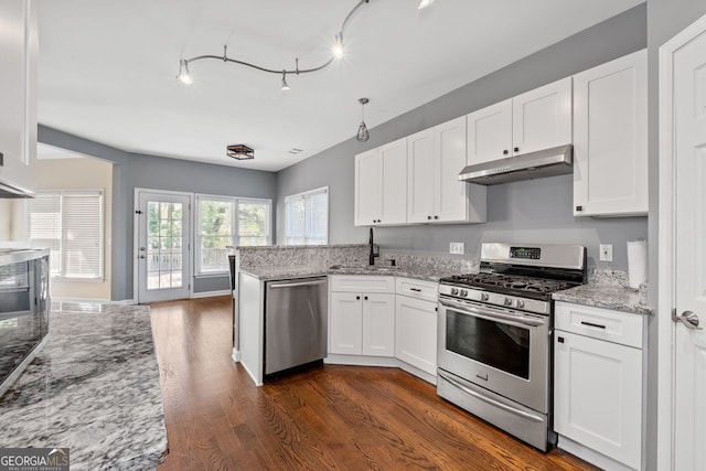 kitchen with a sink, stainless steel appliances, white cabinetry, under cabinet range hood, and dark wood-style floors