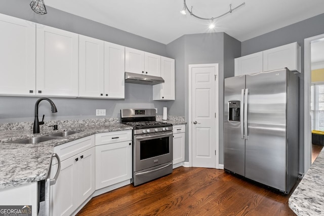 kitchen with a sink, stainless steel appliances, white cabinets, under cabinet range hood, and dark wood-type flooring