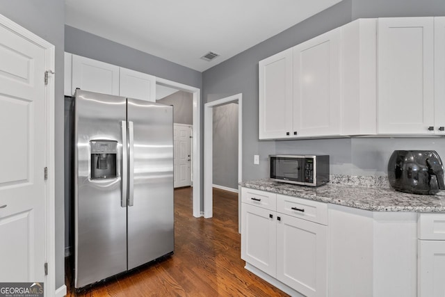 kitchen featuring appliances with stainless steel finishes, dark wood-type flooring, and white cabinetry
