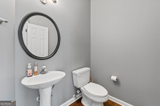 bathroom featuring wood finished floors, toilet, and baseboards