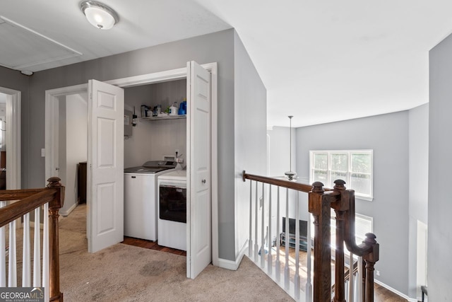 laundry area with laundry area, baseboards, washer and dryer, attic access, and light colored carpet