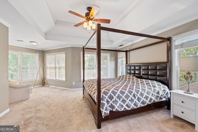 bedroom featuring a raised ceiling, crown molding, light colored carpet, and multiple windows