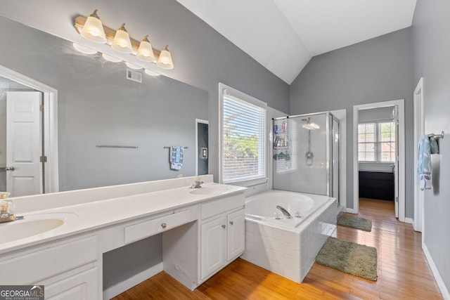 bathroom with vaulted ceiling, visible vents, a sink, a bath, and a stall shower