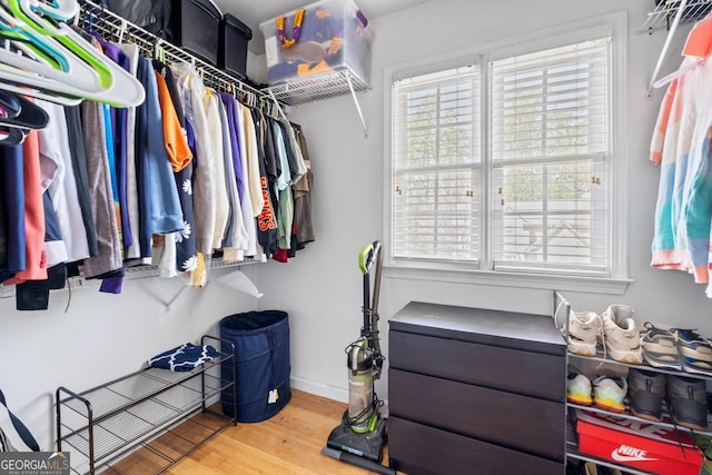 walk in closet with wood finished floors